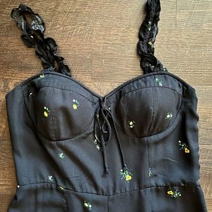 Black floral jumpsuit with build in cups, ruffled straps, and a cinched back.